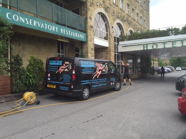 Far view of Crystal Clean van and a worker at work