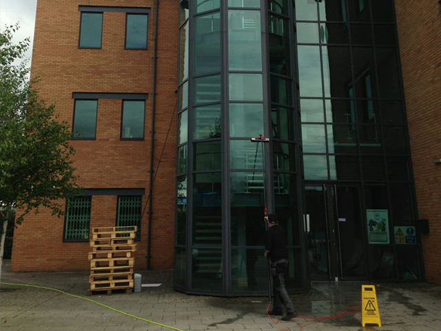 Front view of a glass building being window cleaned